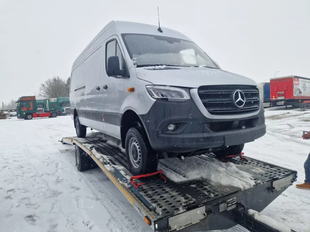 Baltas Mercedes mikroautobusas transportuojamas ant tralo